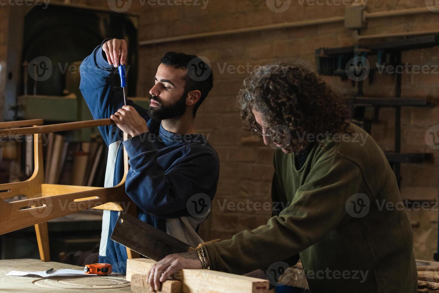 Male artisans creating wooden furniture in workshop photo