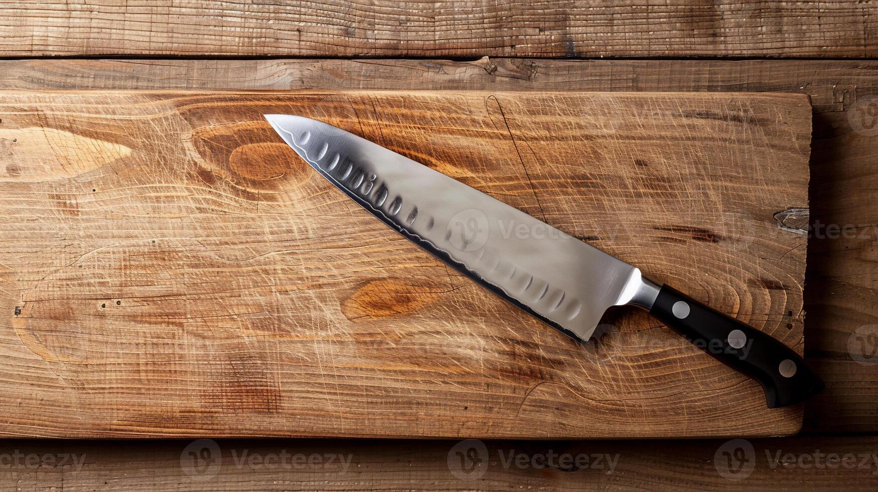 Sharp chef's knife on wooden cutting board photo