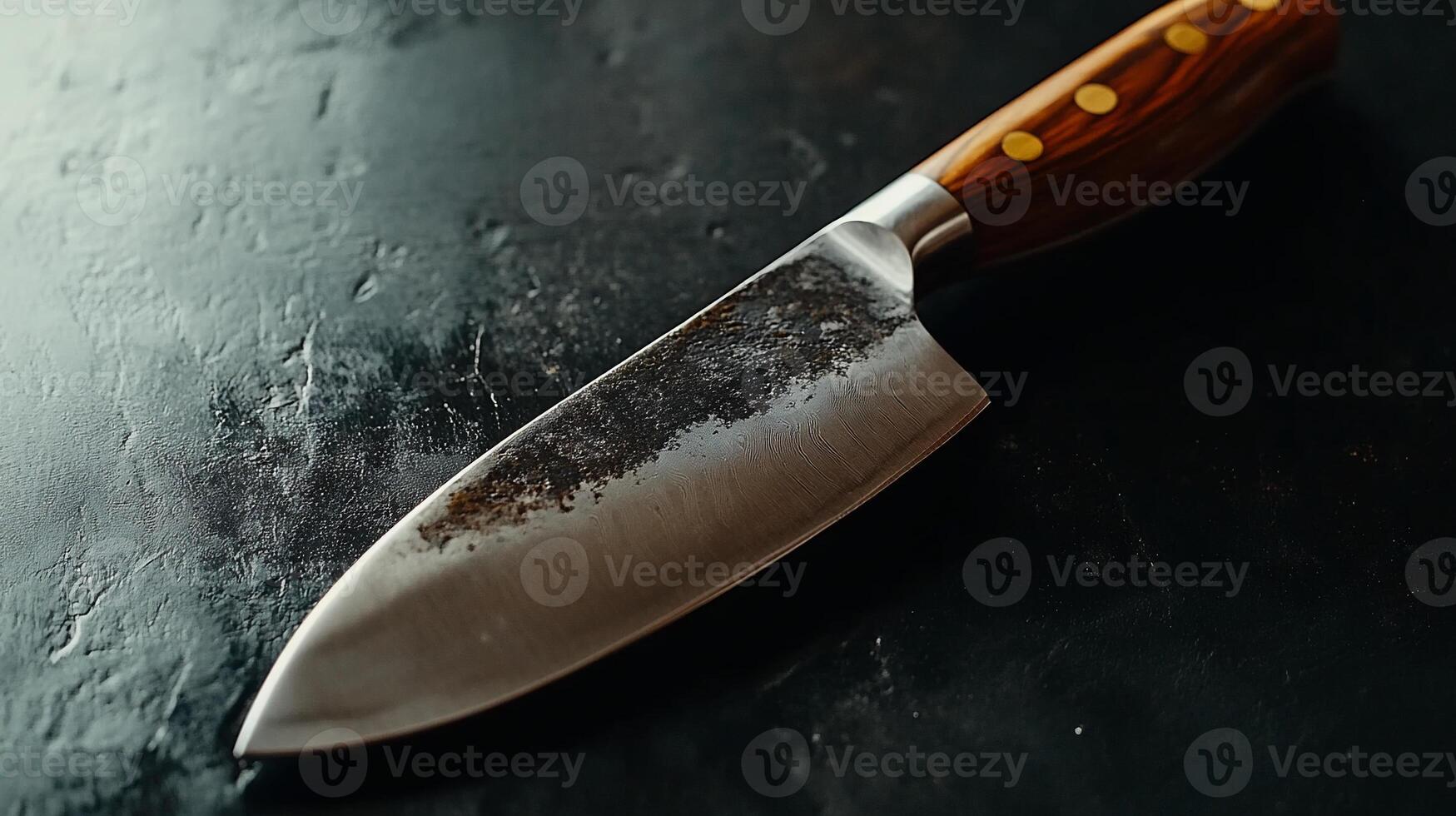 A knife sitting on a table with a black background photo