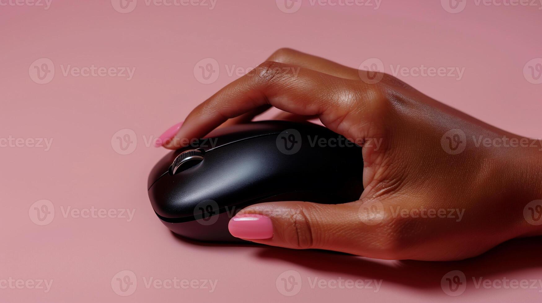Close-up of a hand using a wireless computer mouse on a pink background photo