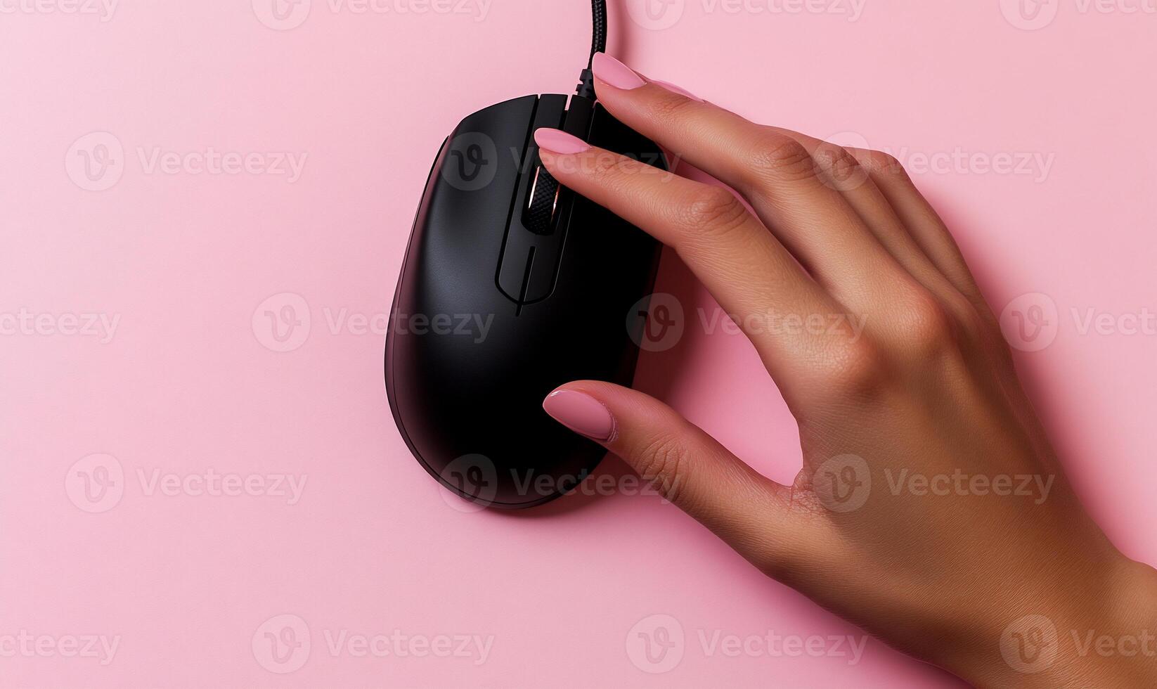 Hand using black computer mouse on pink background photo
