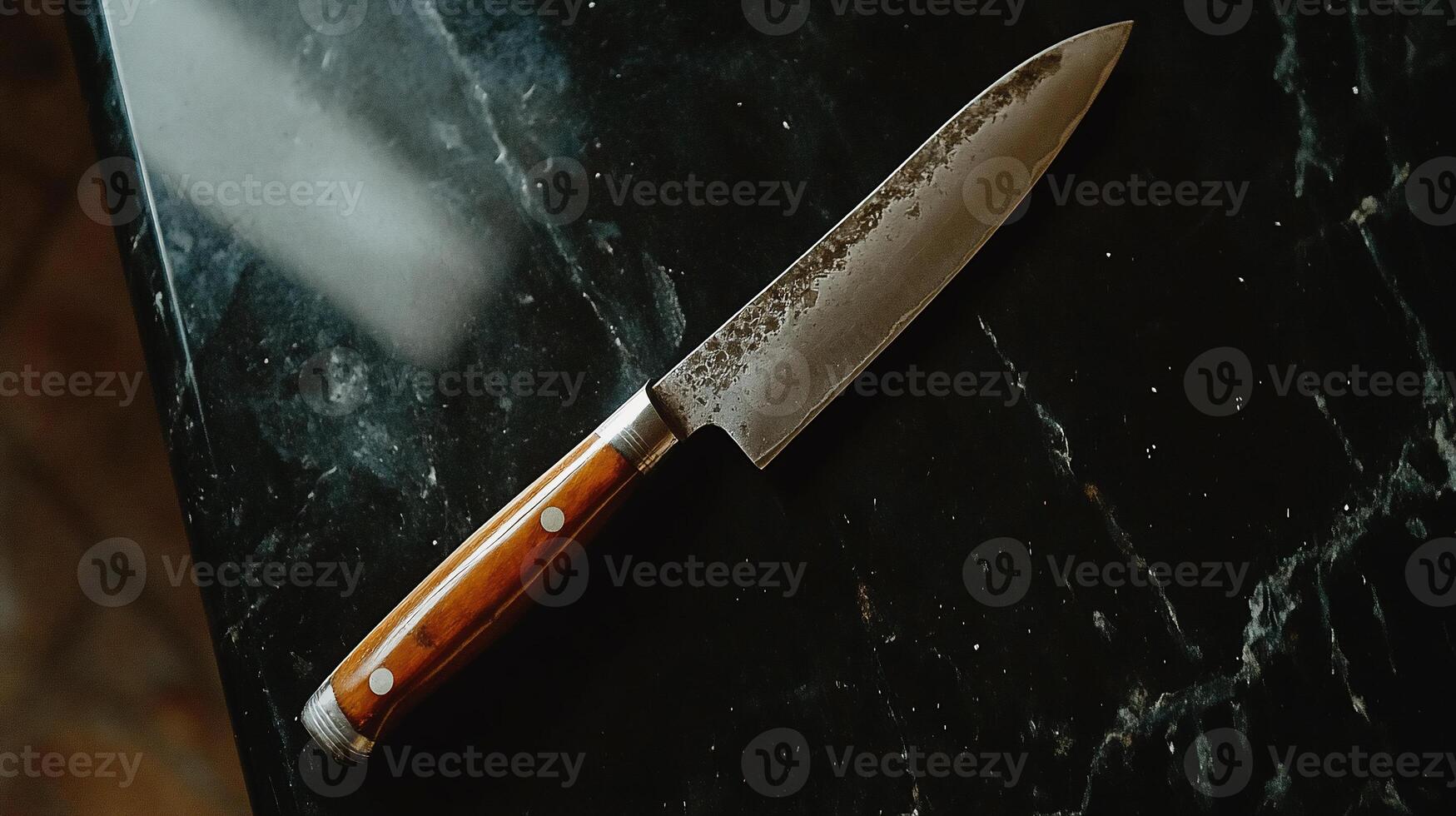 High-quality kitchen knife on dark surface photo