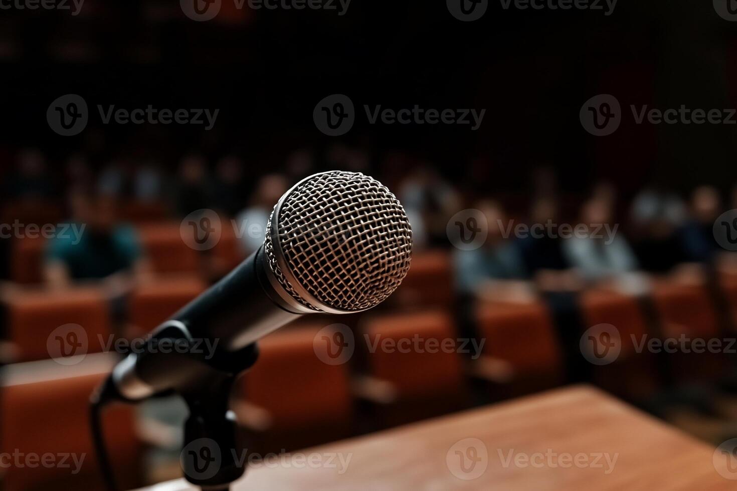 Microphone on a podium in front of an audience photo