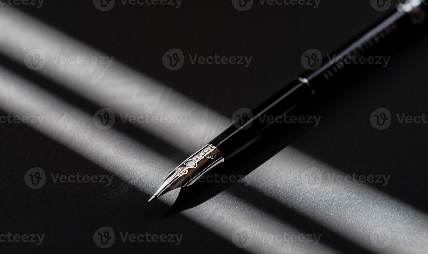 Elegant black fountain pen with silver nib, angled on a dark surface, illuminated by sunlight photo