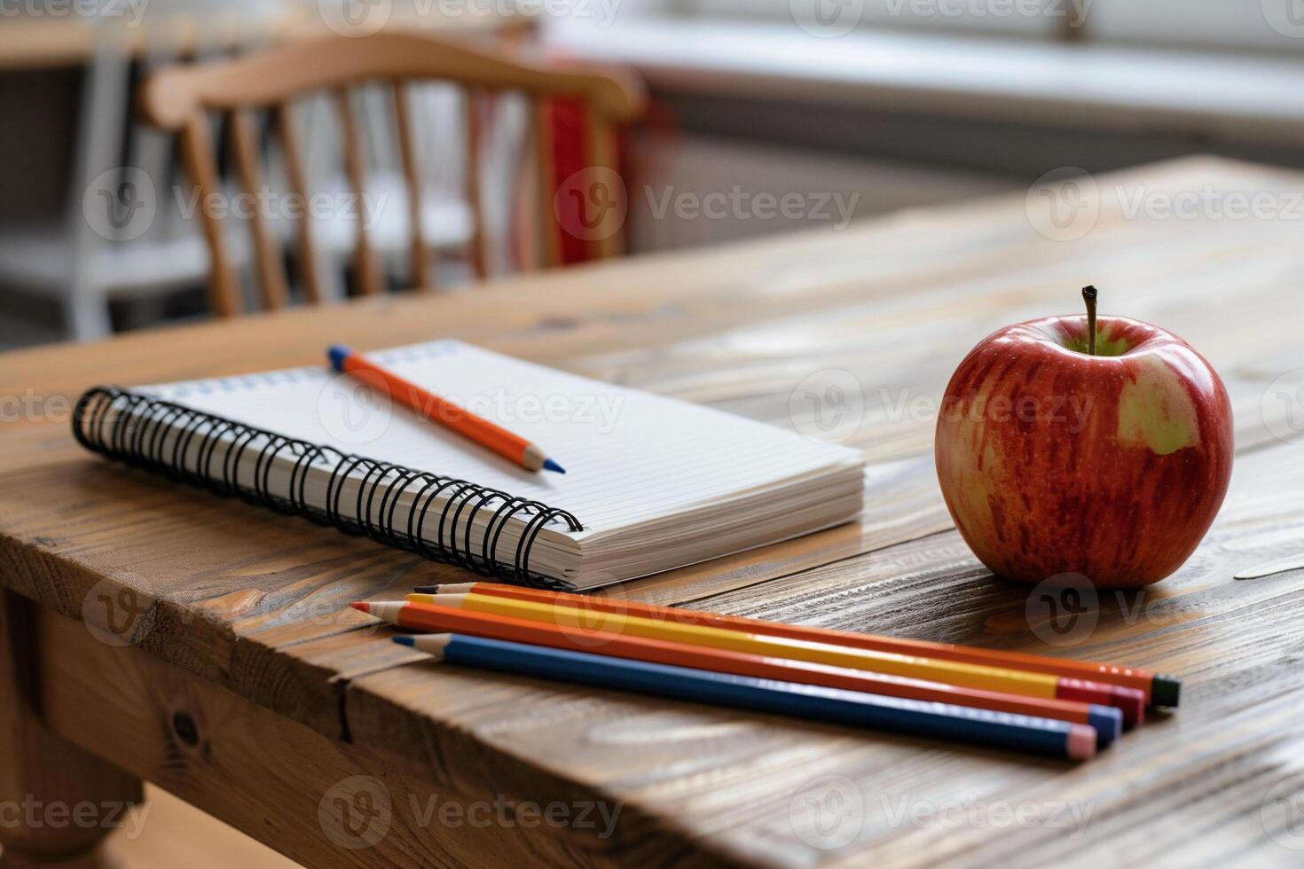 Classroom desk with notebook, pencils and apple photo