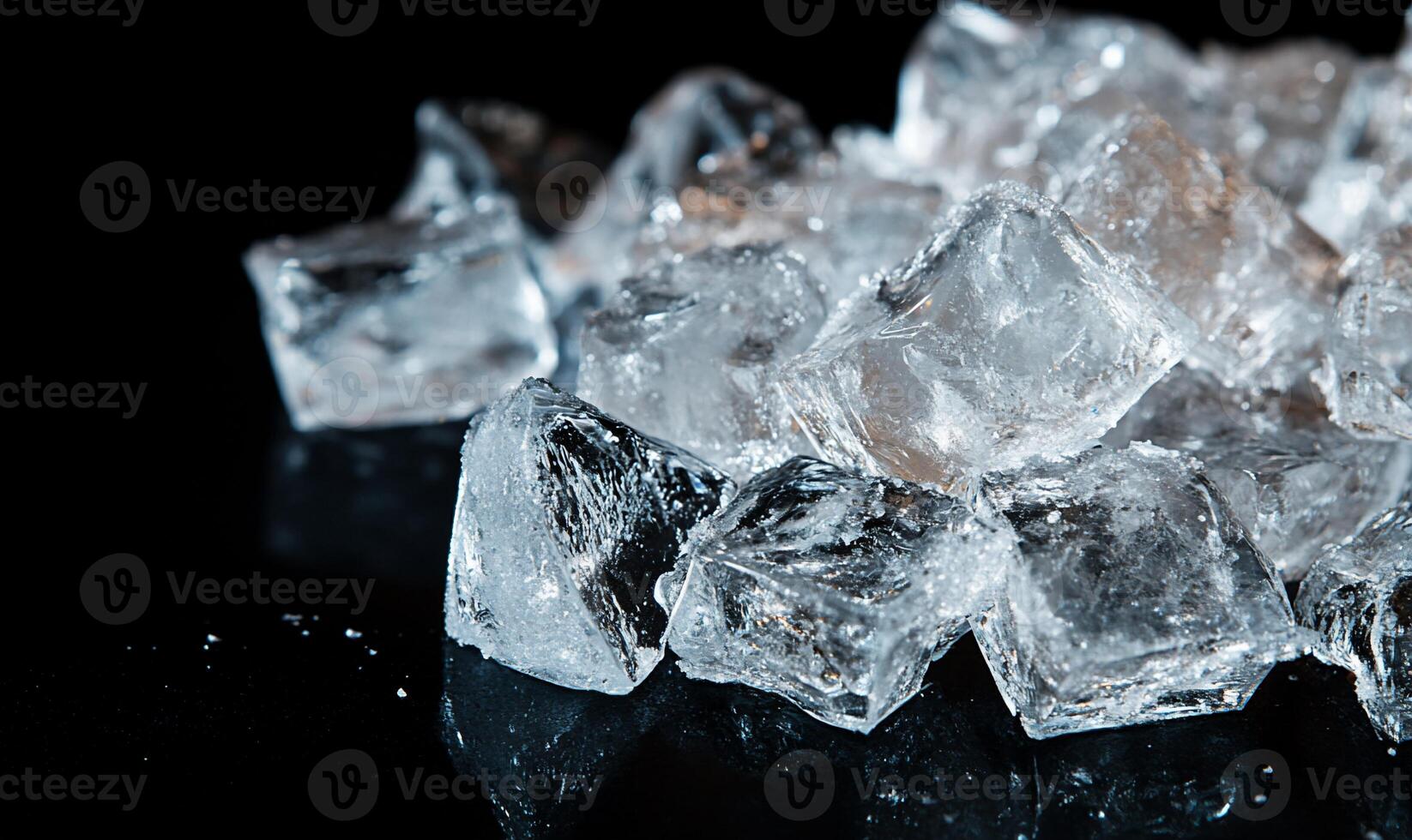 A pile of ice cubes on a black surface photo