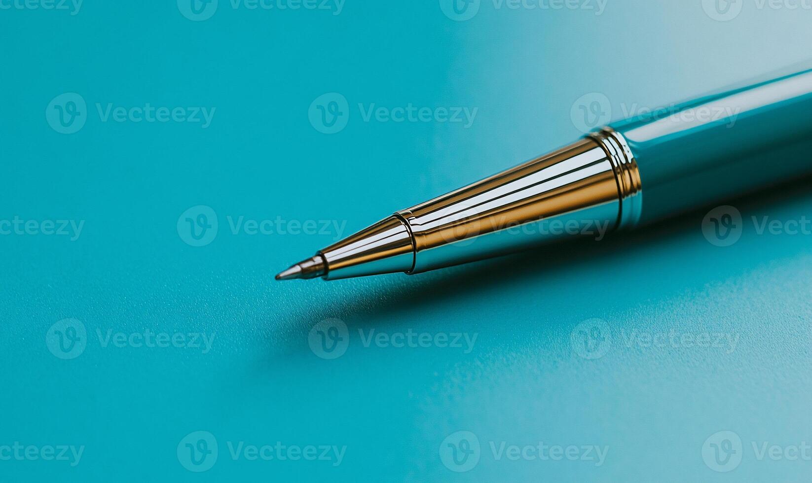 Close-up of a pen tip on a vibrant blue surface. Detailed view of the pen's metal components photo