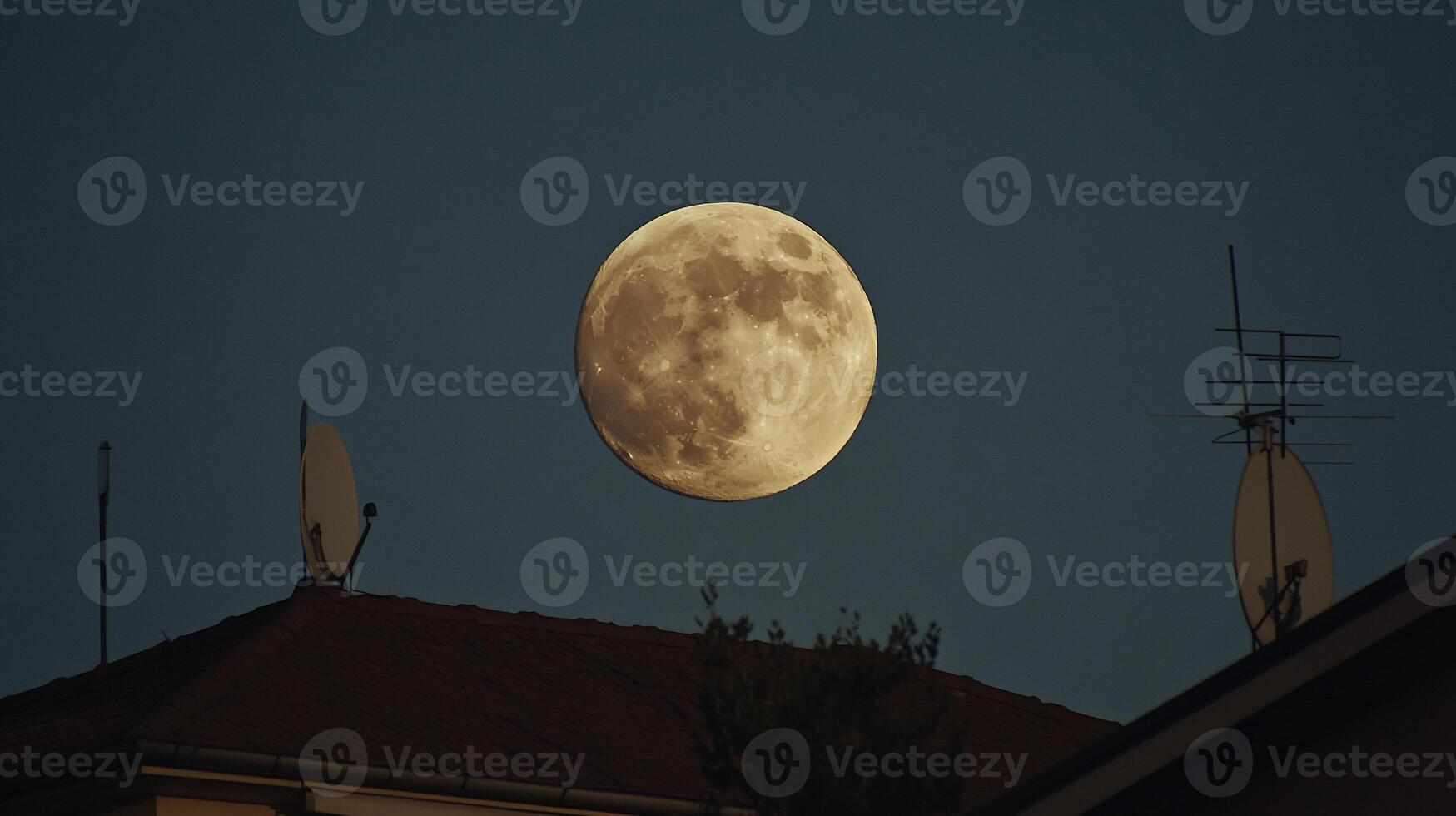 Full moon over rooftops at dusk photo
