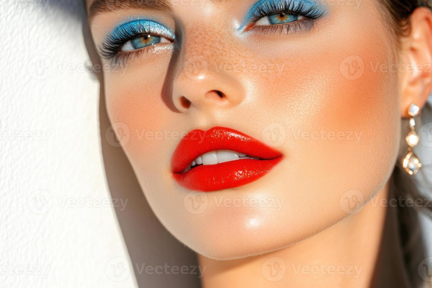 High-end beauty campaign showcasing model with red lips and icy blue eyeshadow in soft natural light photo