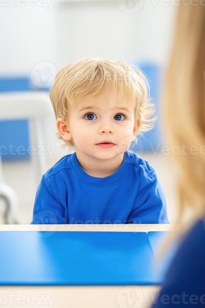 Young autistic child engages with caregiver using communication board to explore alternative communication techniques photo