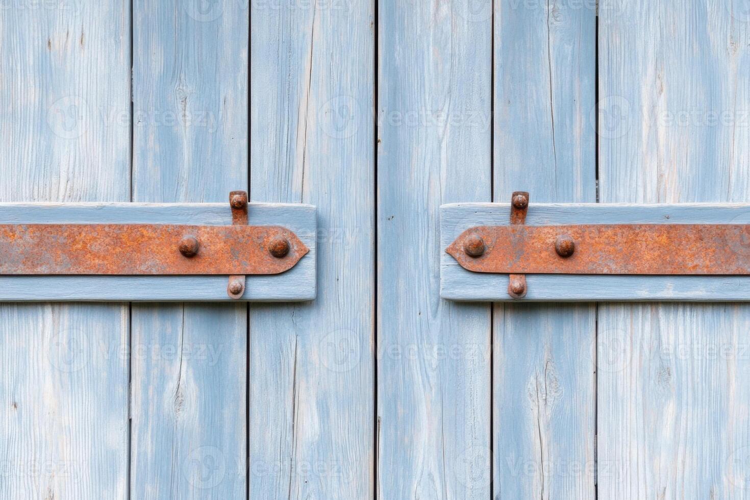 Old gray barn door with weathered textures and rusted hinges in a rural countryside setting photo