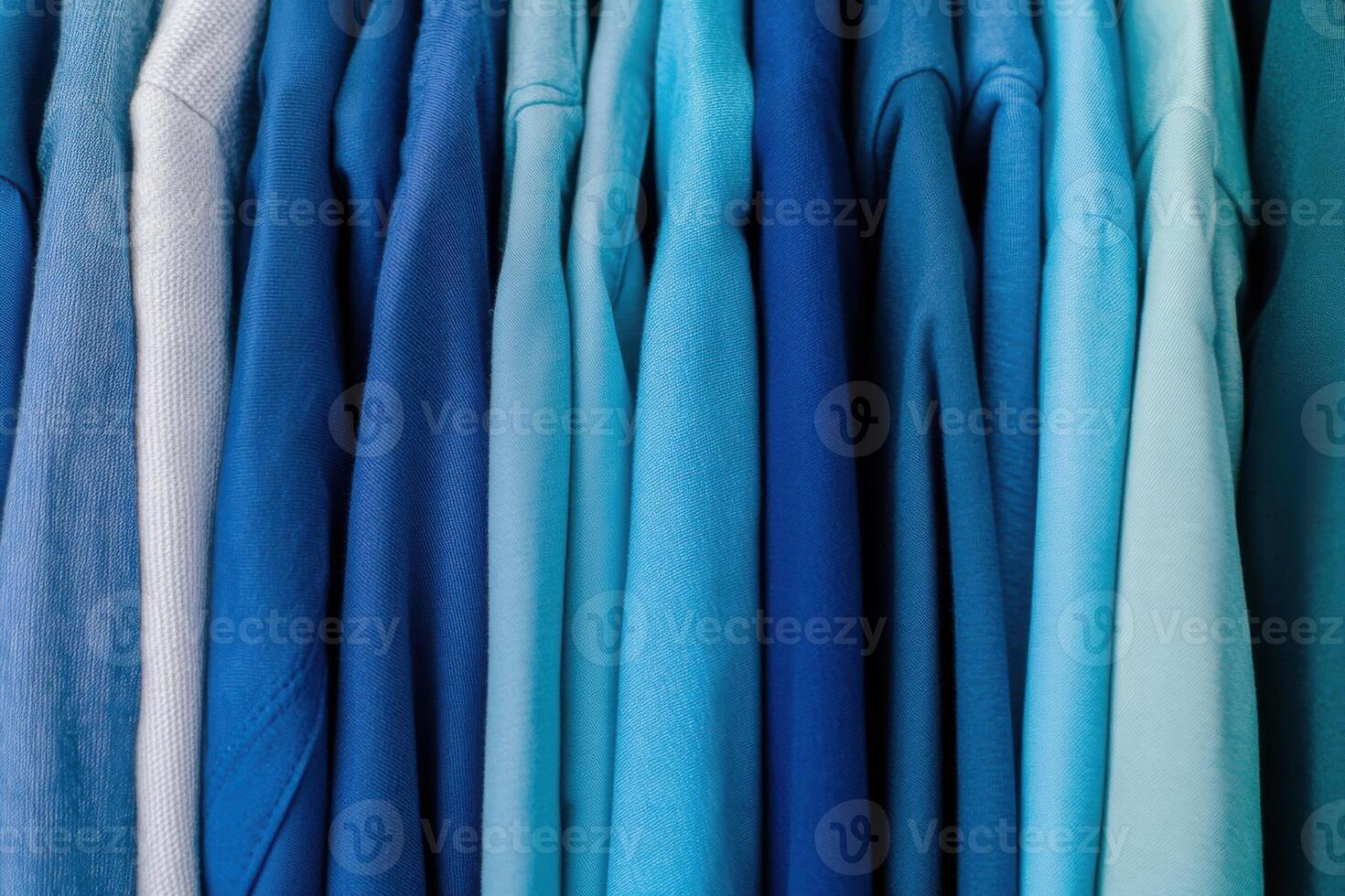 Monochrome wardrobe rack showcasing a gradient of clothing in various shades of blue from light to deep Little Boy Blue arranged neatly in a stylish display photo