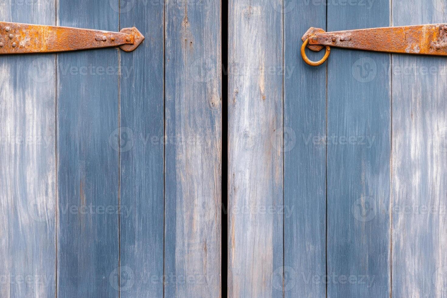 Old gray barn door with weathered textures and rusted hinges set against a rural countryside background showcasing natures beauty and timeless charm photo