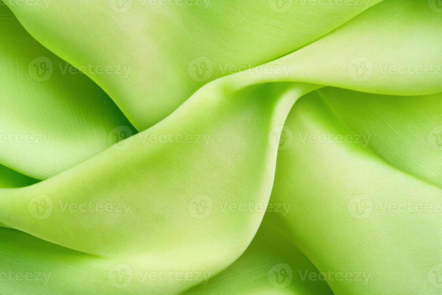Vibrant folds of lime green fabric create dramatic texture and depth in textile design with elegant movement photo