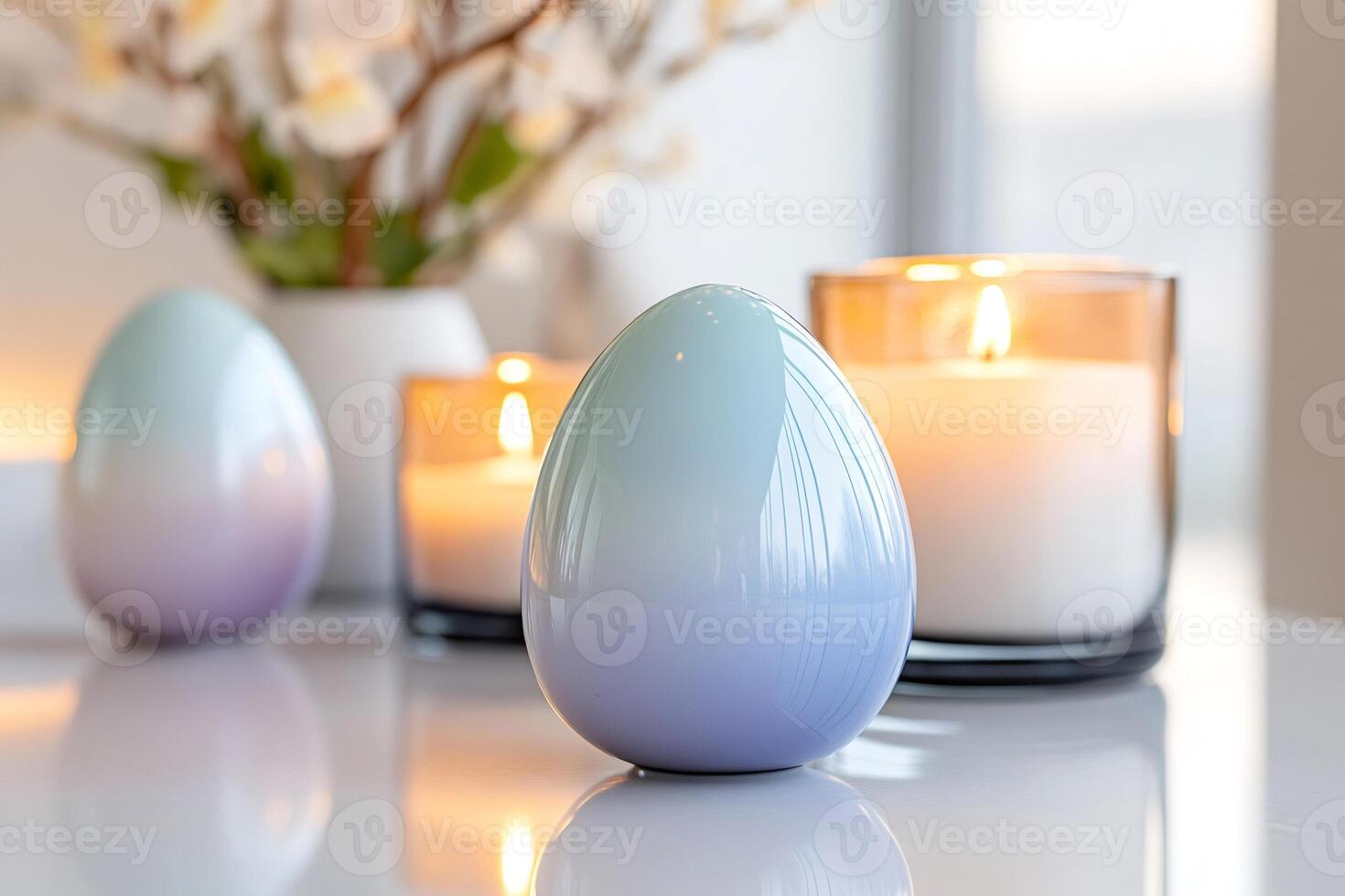 Easter eggs and lit candles creating a cozy atmosphere on a white table photo