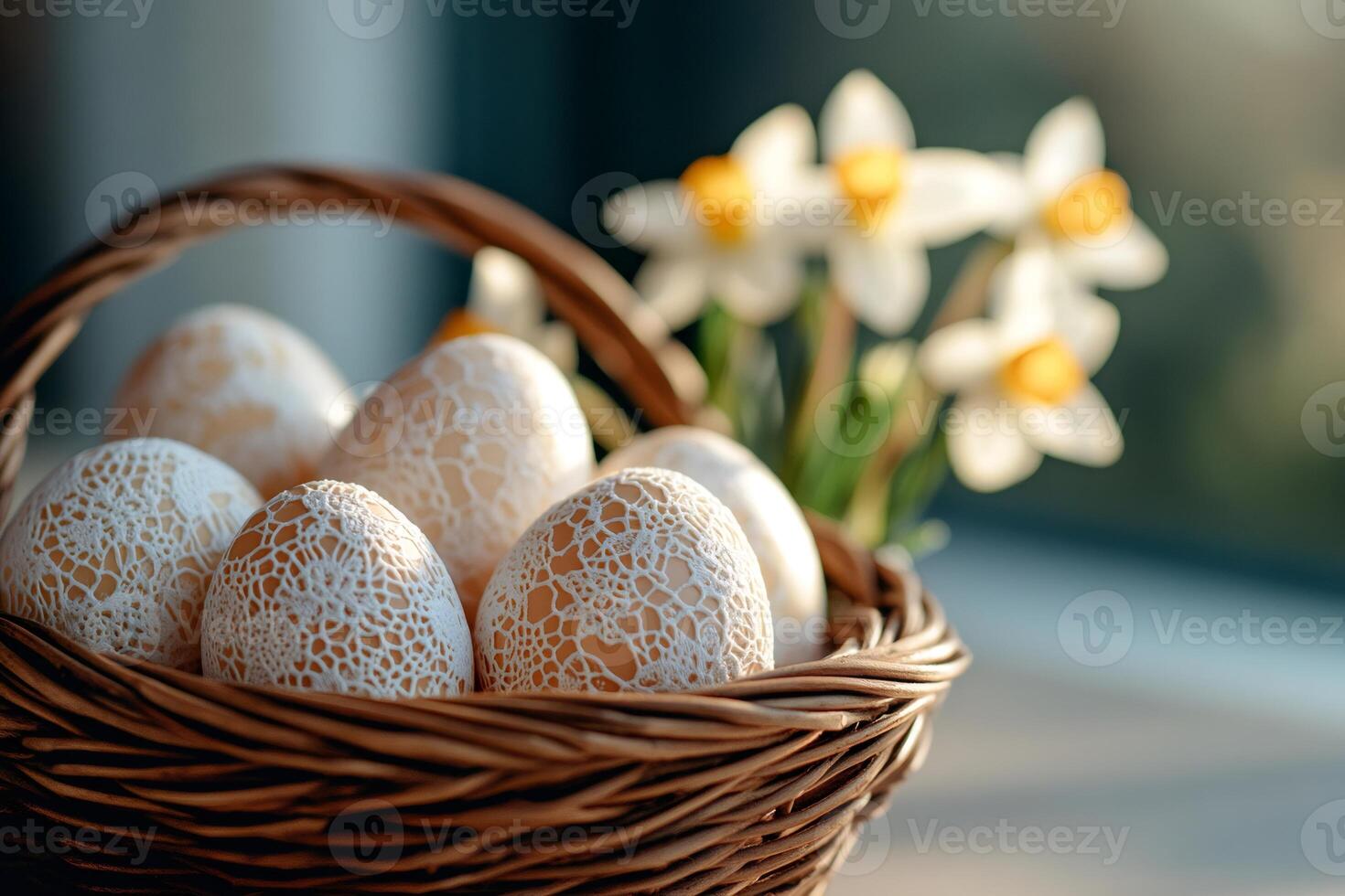 Easter eggs decorated with white lace in a wicker basket with daffodils in the background photo