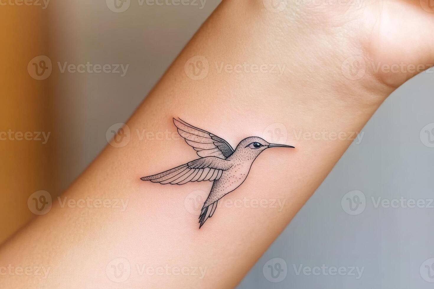 Small hummingbird tattoo with spread wings on wrist photo