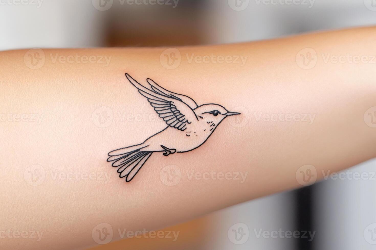 Delicate hummingbird tattoo flying on arm skin photo