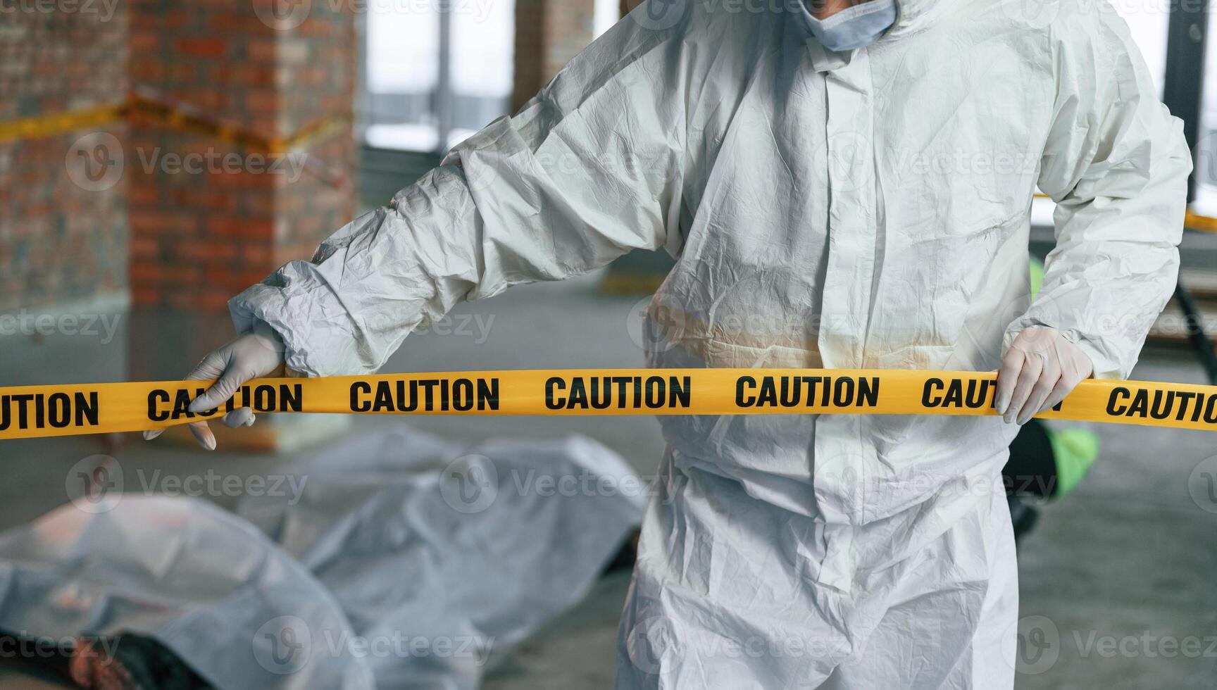 Holding caution, police tape. Detectives are, collecting evidence in a crime scene near dead body photo