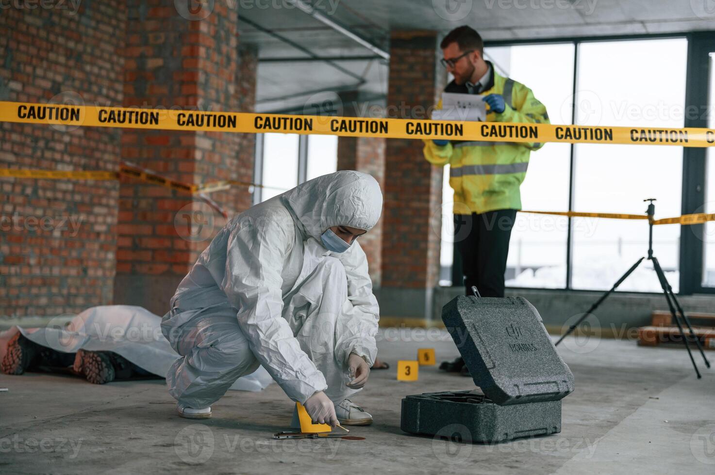 Knife as ,evidence. Blood is on the floor. Detectives are in a crime scene near dead body photo