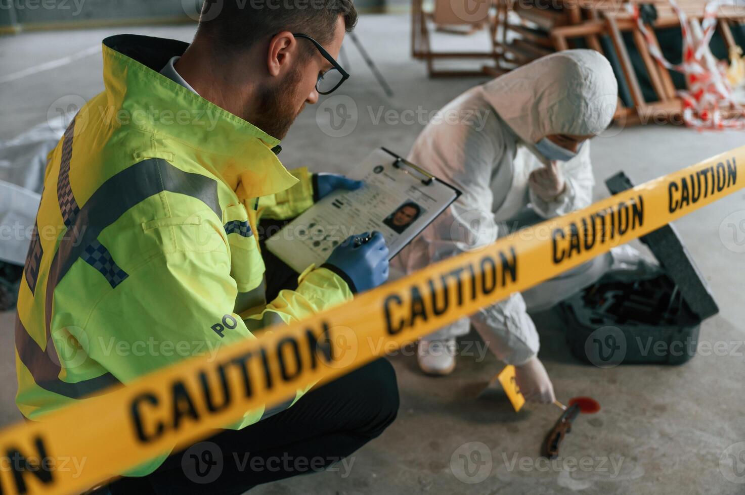 Caution, police tape. Detectives are collecting evidence in a crime scene near dead body photo