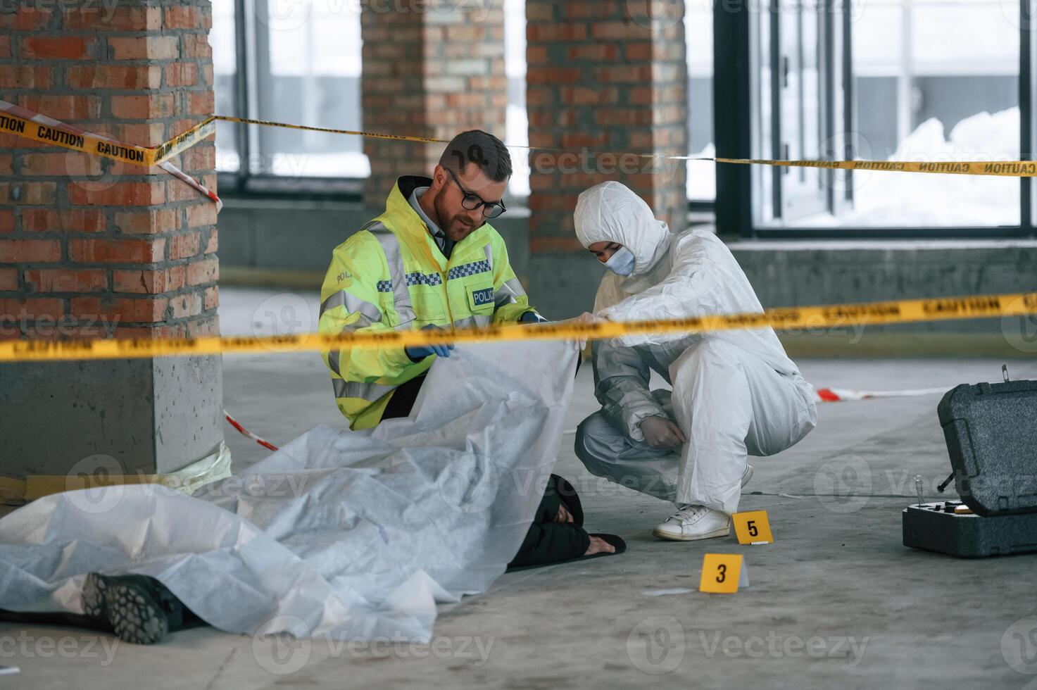 Dead body ,is on the ground. Detectives are collecting evidence in a crime scene photo