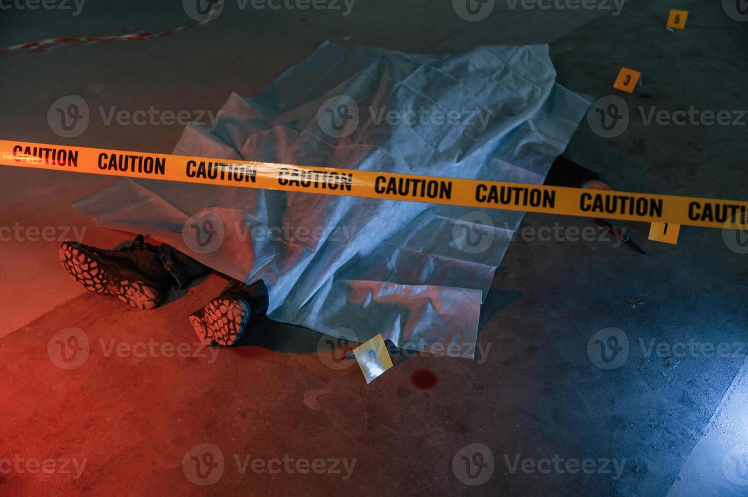 Knife and blood. Dead body of a man is on the ground, covered in white cloth. Conception of murder, homicide photo