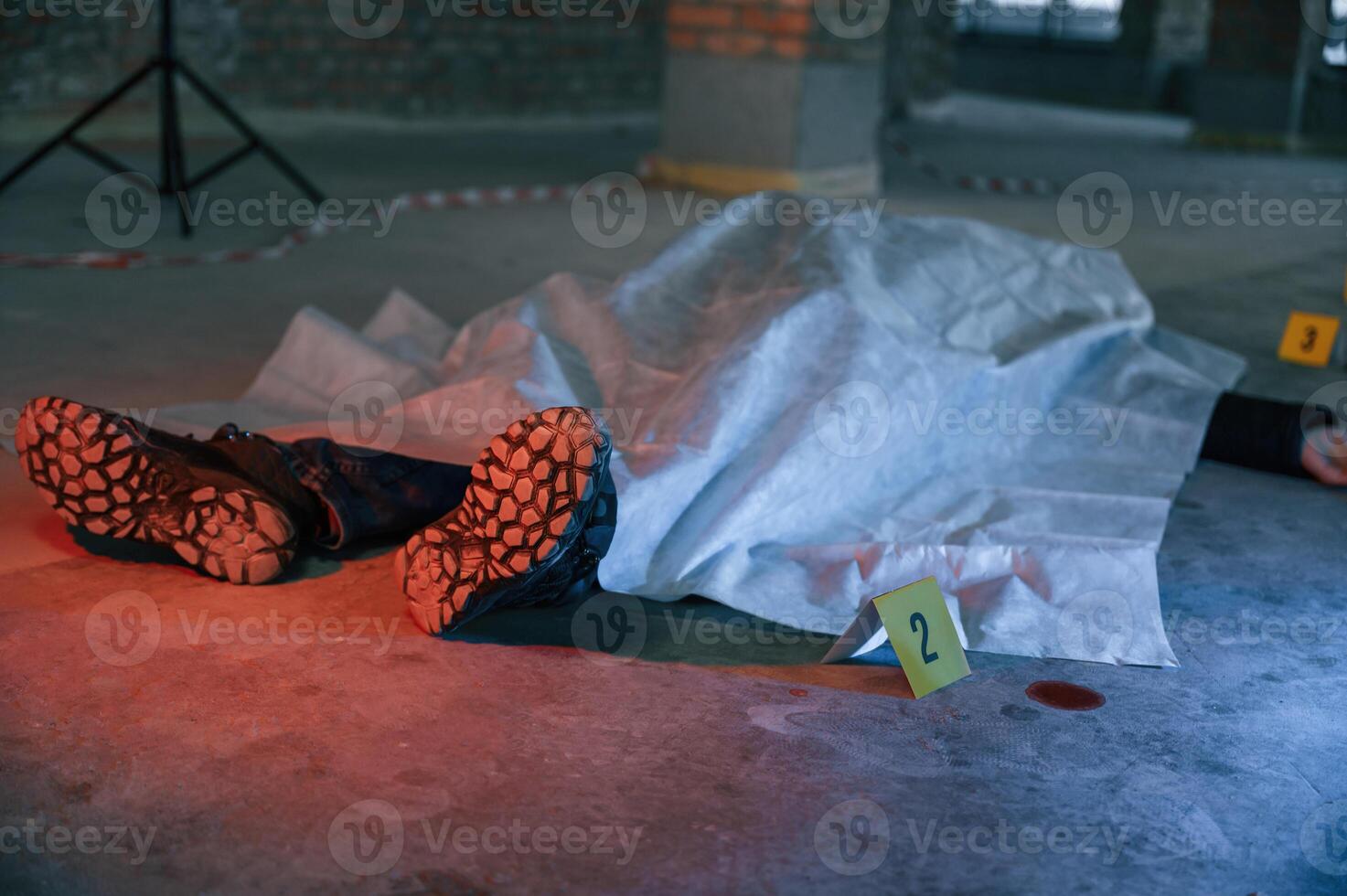 Dead body of a, man is on the ground, covered in white cloth. Conception of murder, homicide photo
