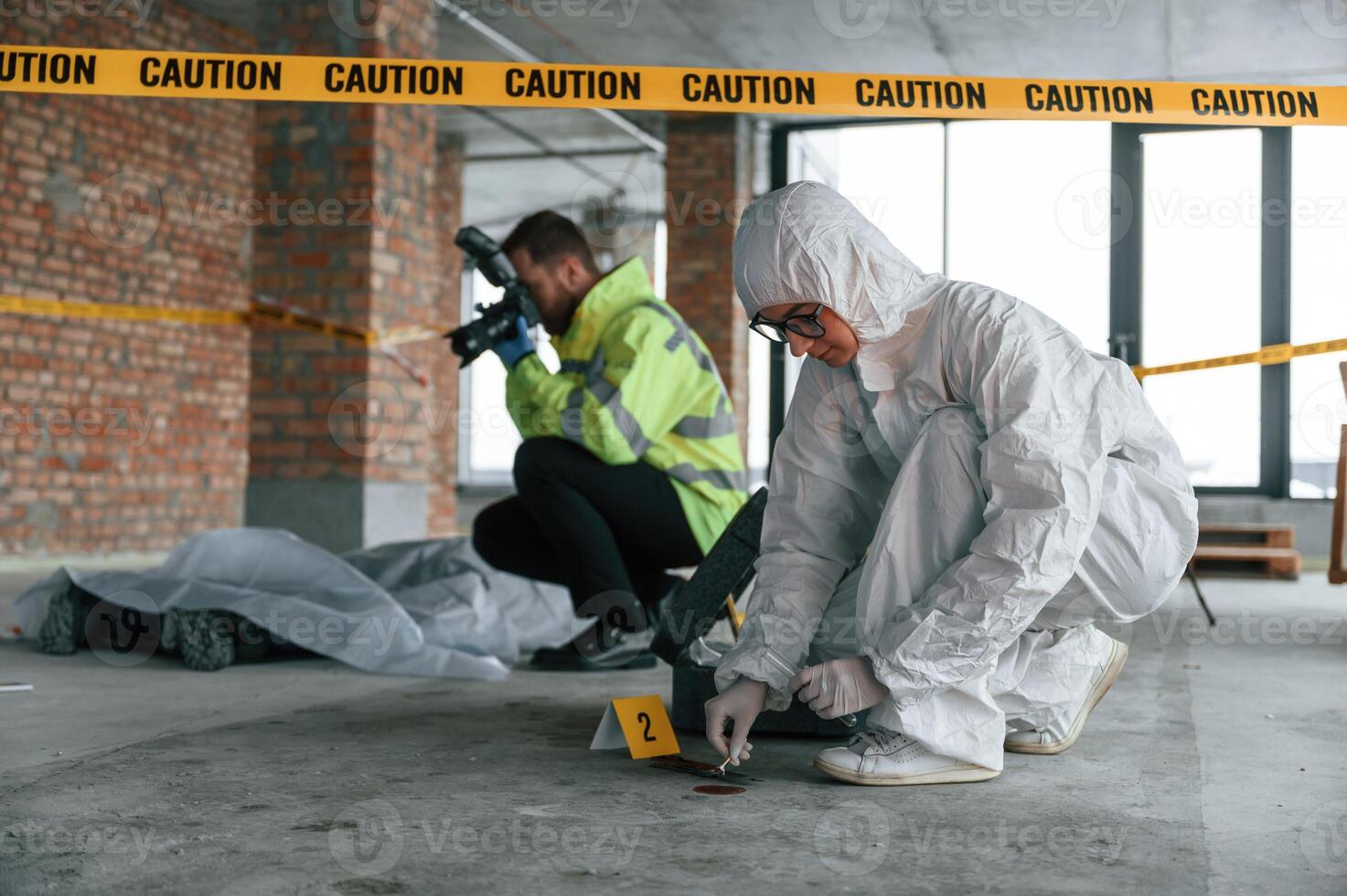 Knive and, blood is on the ground. Detectives are collecting evidence in a crime scene near dead body photo