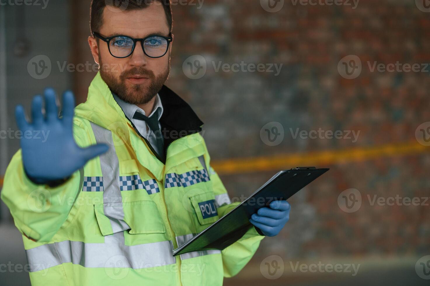 No trespassing, stop gesture by a hand. Male detective is collecting evidence in a crime scene on the construction site photo