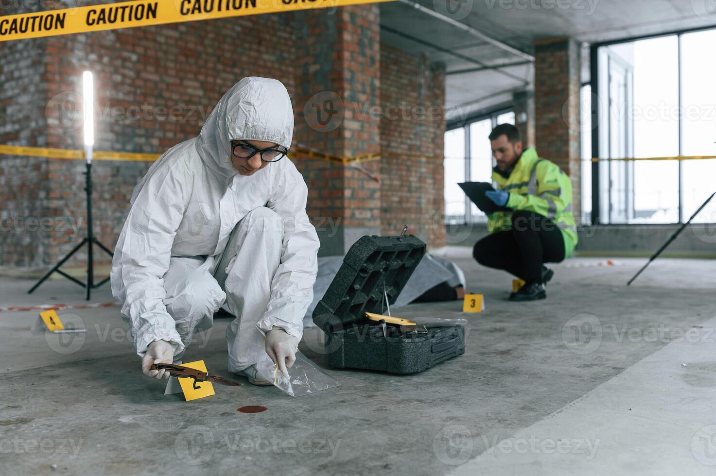 At ,daytime. Detectives are collecting evidence in a crime scene near dead body photo