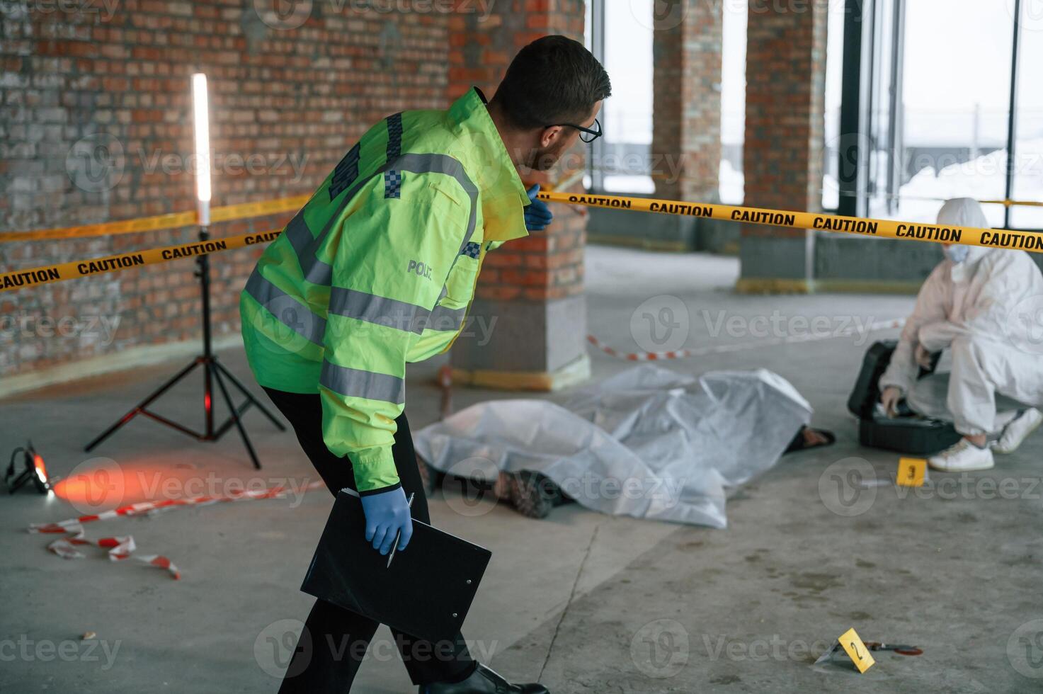 Detectives, are collecting evidence in a crime scene near dead body. Forensic specialists are making expertise photo