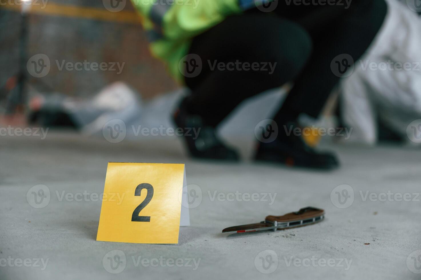 Detectives are collecting evidence in a crime scene near dead body. Forensic specialists are making expertise photo