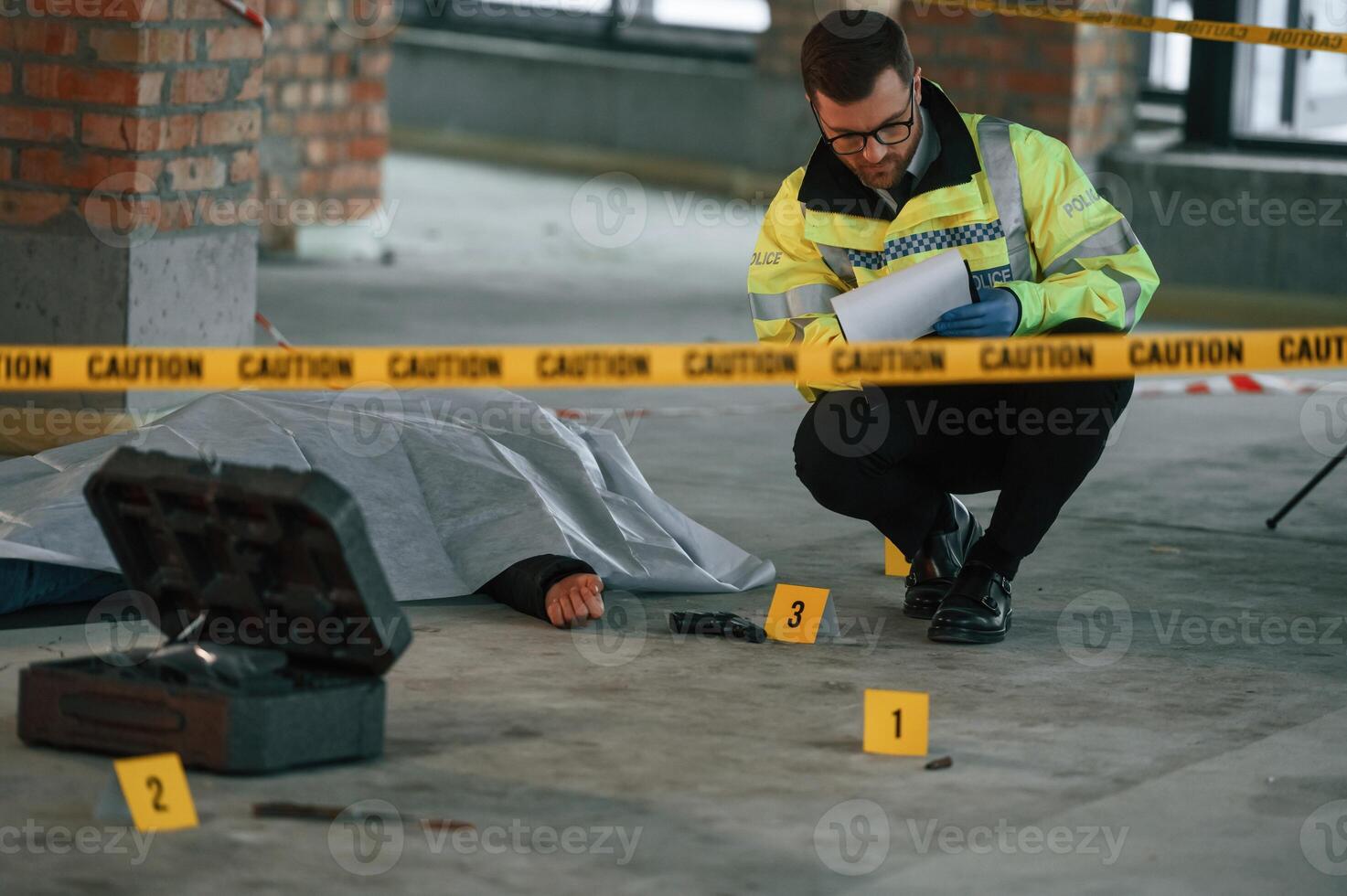 Male detective, is ,collecting ,evidence in a crime scene near dead body on the construction site photo