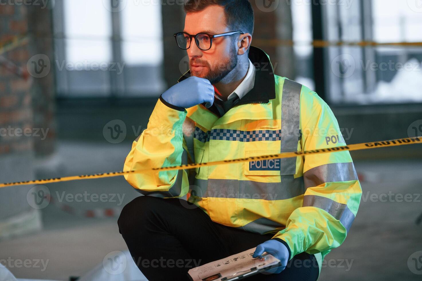 Sitting and thinking. Male detective is collecting ,evidence in a crime scene on the construction site photo