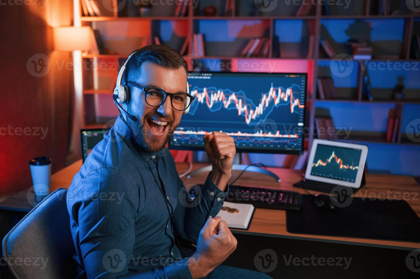 Happy, stock trader is working by pc indoors and celebrating success. Conception of exchange and money photo