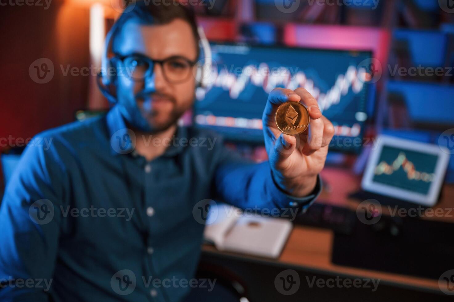 Holding ,bitcoin. Stock trader is working by pc indoors. Conception of exchange and money photo