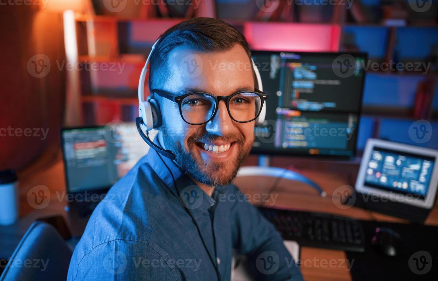 Professional programmer is working indoors,. Neon lighting photo