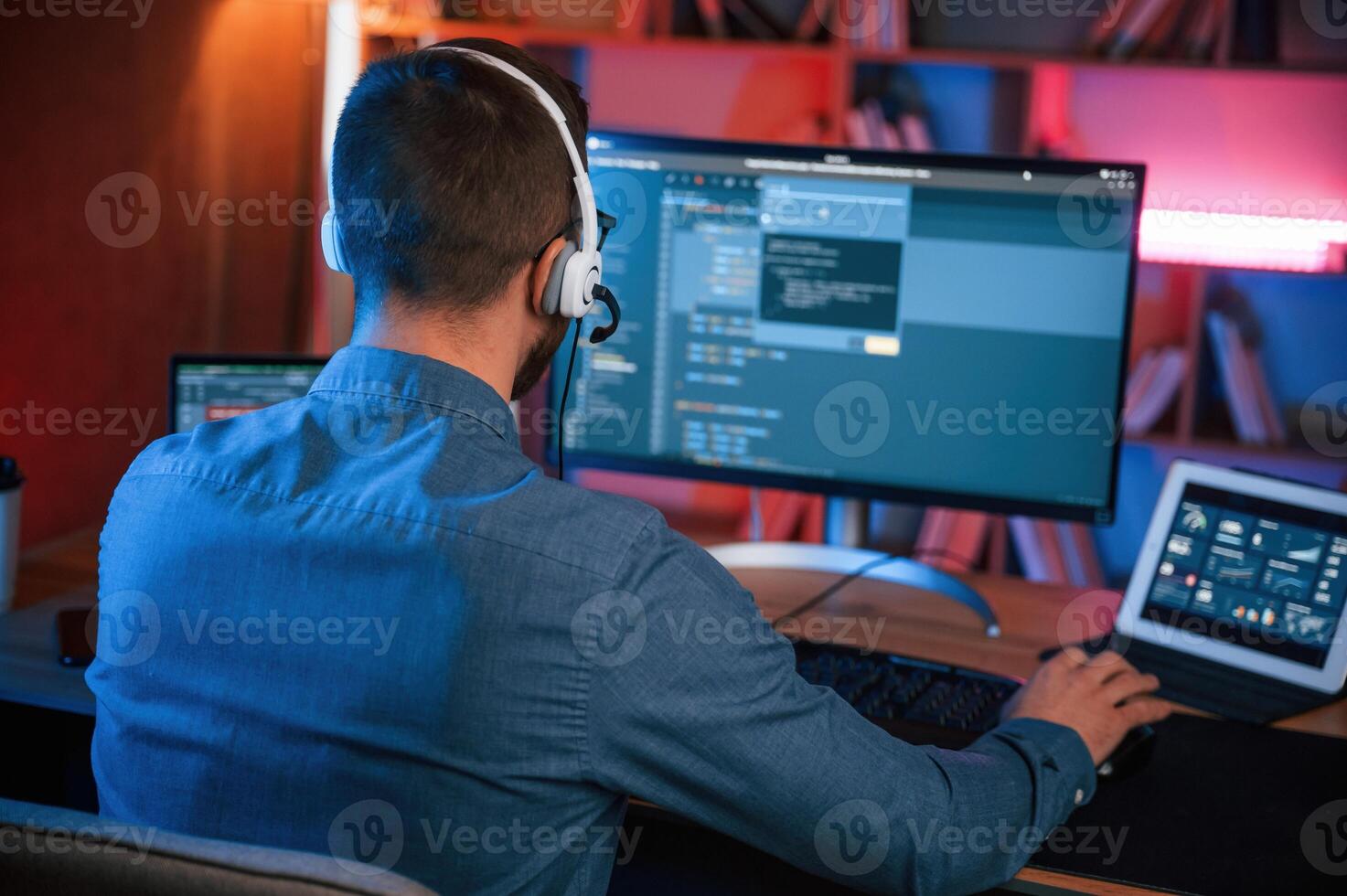 Professional programmer is working ,indoors.. Neon lighting photo