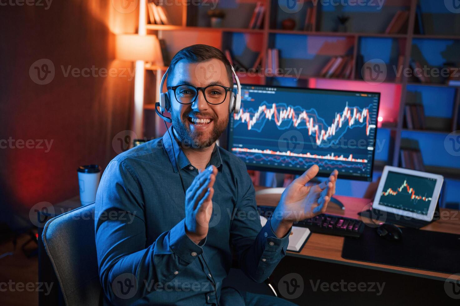 Sitting and ,looking at the camera. Stock, trader is working by pc indoors. Conception of exchange and money photo