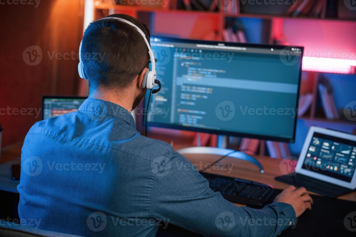 Professional programmer is working indoors.. Neon lighting photo