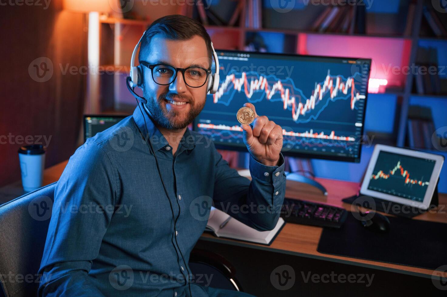 Holding bitcoin.. Stock, trader is working by pc indoors. Conception of exchange and money photo