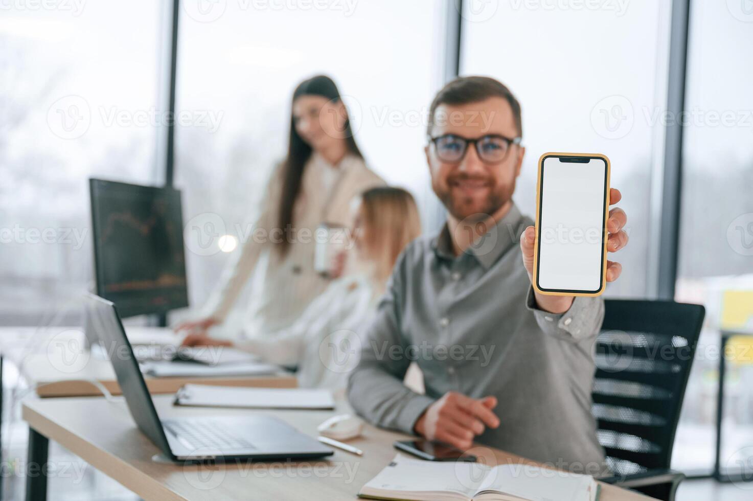 Smiling ,,and holding smartphone. Successful team are working together in the office. Conception of business photo