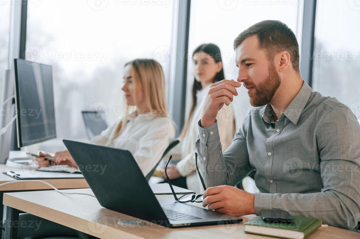 Man ,is feeling bad about failure. Team are working together in the office. Conception of business photo