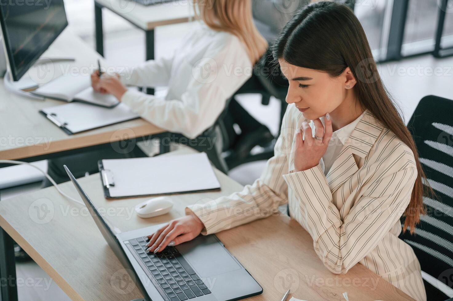 Woman is sitting by a table ,with laptop. Successful ,team are working together in the office. Conception of business photo