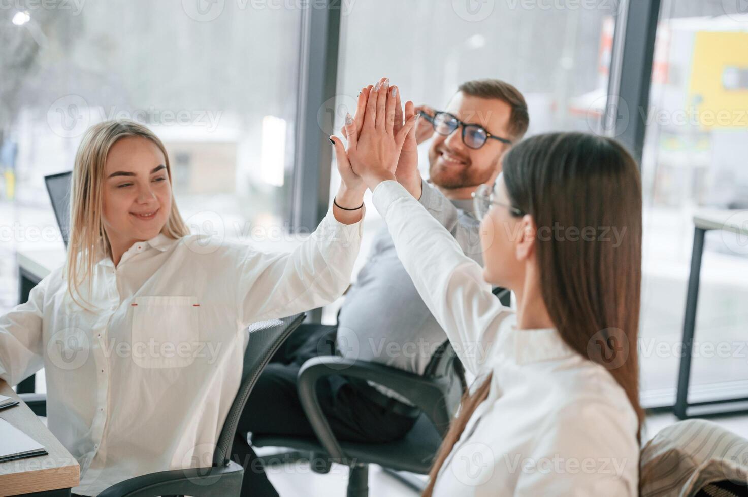 Doing high five.. Successful team are working together in the office. Conception of business photo
