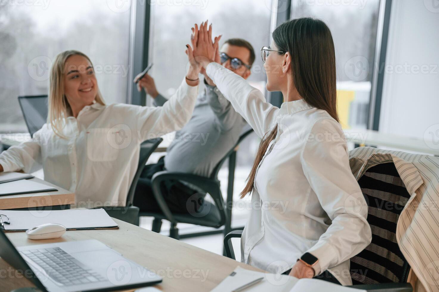 Doing high five.. Successful, team are working together in the office. Conception of business photo
