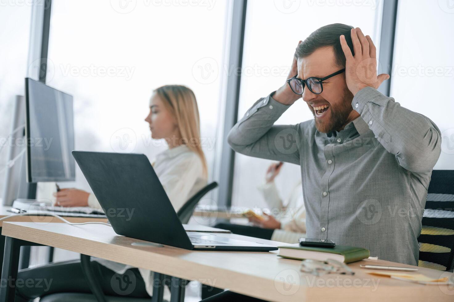 Man is, feeling bad about failure. Team are working together in the office. Conception of business photo