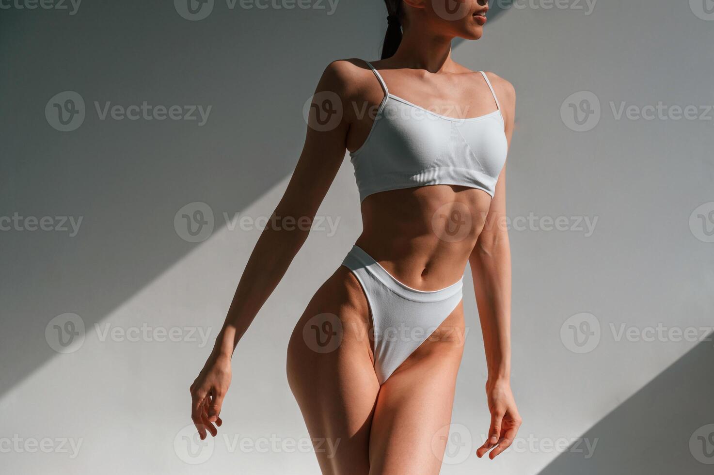Showing new collection, of underwear. Young caucasian woman with slim body shape is indoors in the studio photo