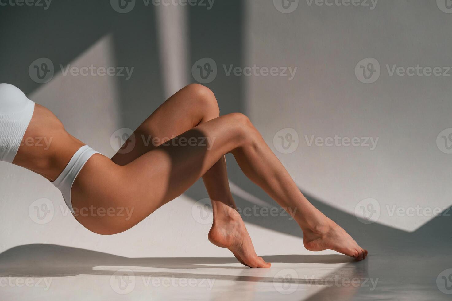 On the, legs and hands. Close up view. Young caucasian woman with slim body shape is indoors in the studio photo